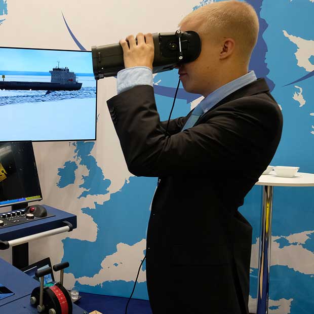 Mann mit VR-Brille vor einer Monitorwand